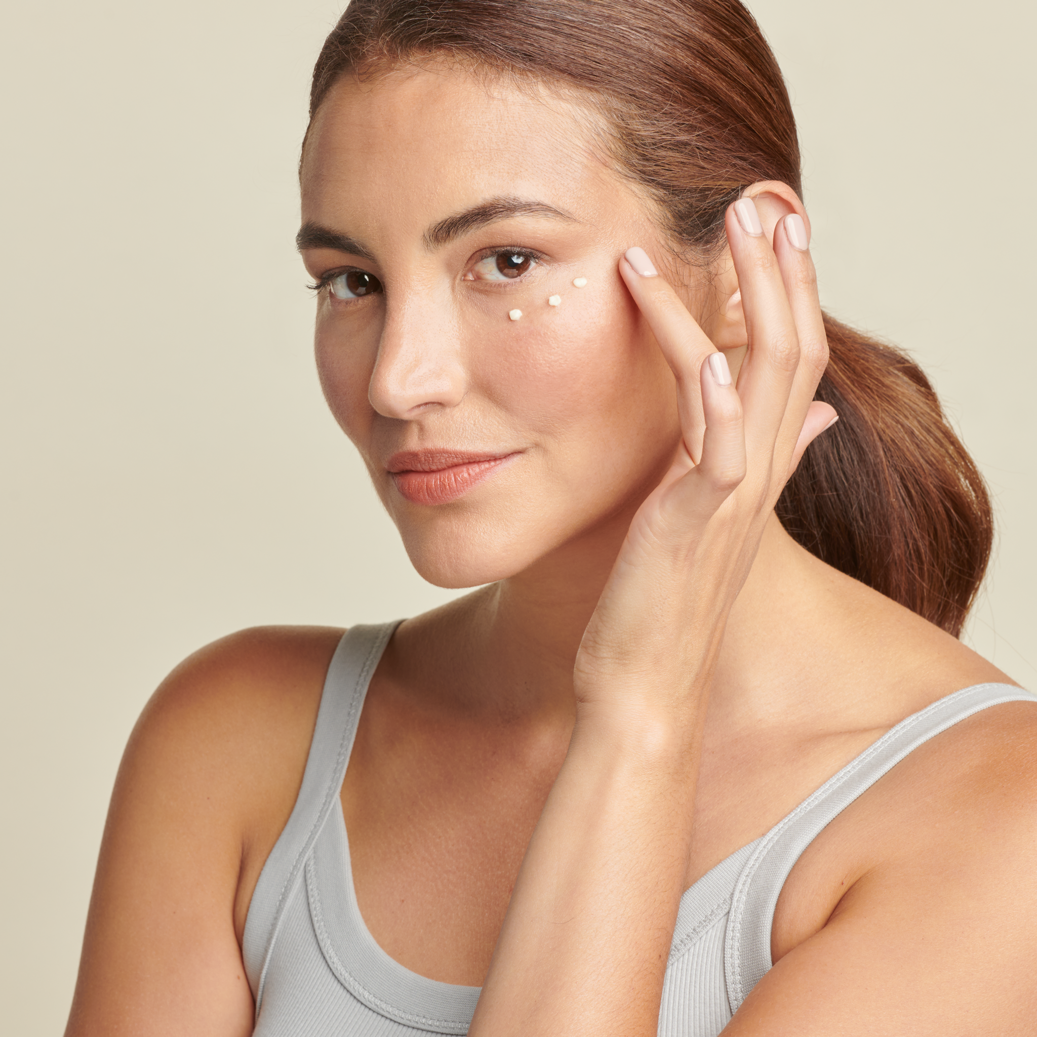 woman applying Total Eye cream || all